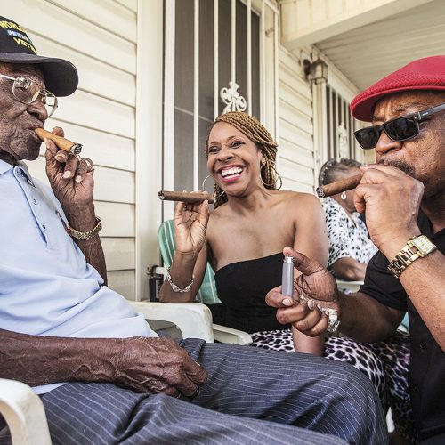 Richard Overton, left,  smokes a cigar with a few neighborhood friends Donna Shorts, center and Martin Wilford Sunday, May 3, 2015, in Austin, Texas.. Overton, is considered to be the oldest living World War II veteran in the United States, celebrated his 109th birthday on a front porch in East Austin with friends and family. Wilford, right, says that he has known Overton for 37 years and he looks at Mr. Overton as if he was his biological father.  (Ricardo B. Brazziell/Austin American-Statesman via AP)
